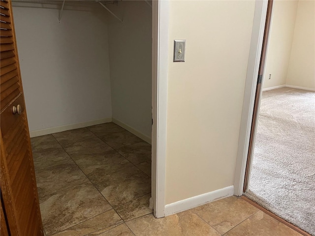 walk in closet with light colored carpet