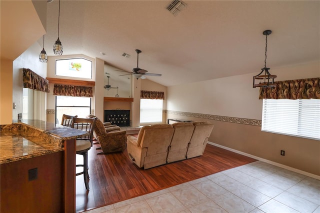 tiled living room featuring lofted ceiling and ceiling fan