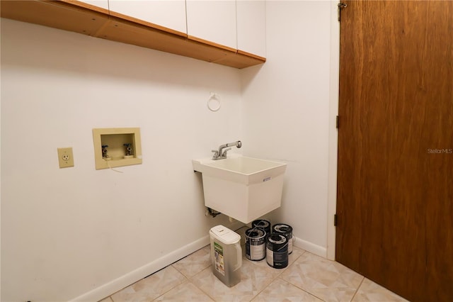 laundry area featuring washer hookup, sink, cabinets, and light tile patterned flooring