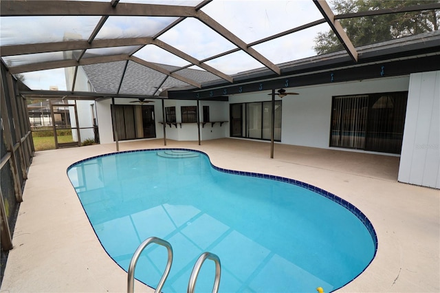 view of swimming pool featuring a patio area, ceiling fan, and glass enclosure