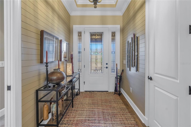 entryway with hardwood / wood-style floors, ornamental molding, and wooden walls