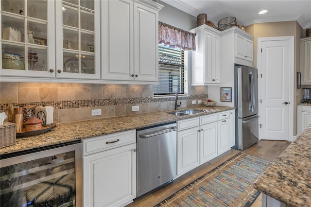 kitchen featuring light stone countertops, appliances with stainless steel finishes, sink, white cabinets, and wine cooler