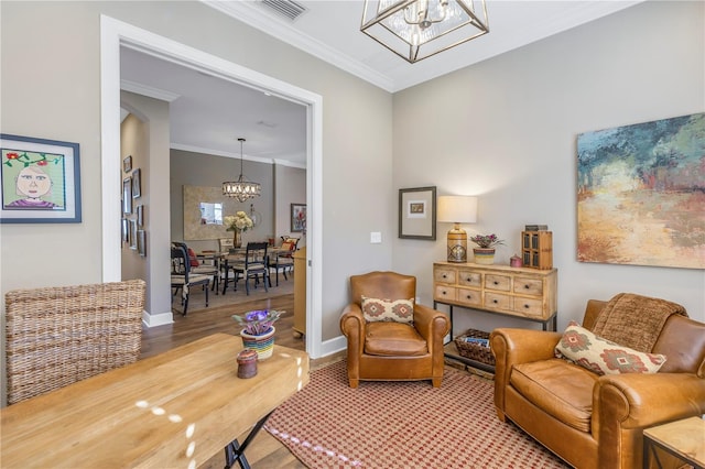 sitting room featuring wood-type flooring, a notable chandelier, and ornamental molding