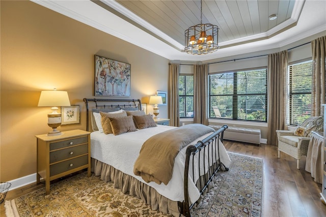 bedroom with hardwood / wood-style floors, a notable chandelier, crown molding, and a tray ceiling