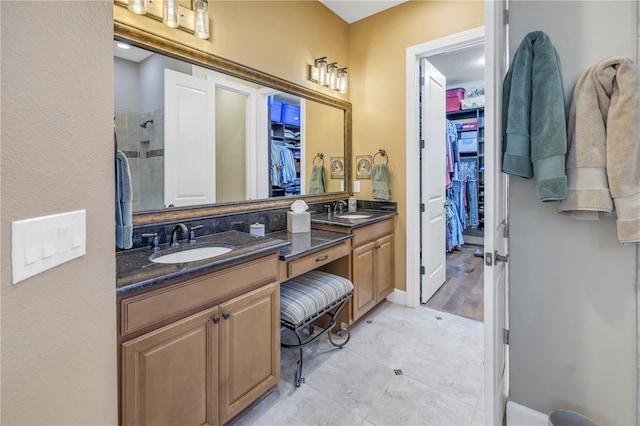 bathroom with tile patterned flooring, vanity, and walk in shower