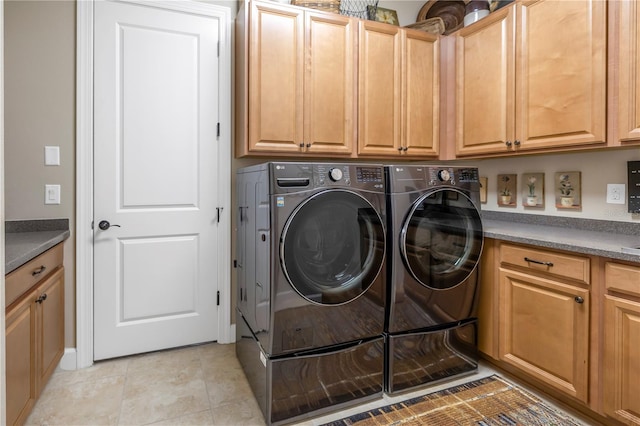 clothes washing area featuring light tile patterned flooring, cabinets, and independent washer and dryer