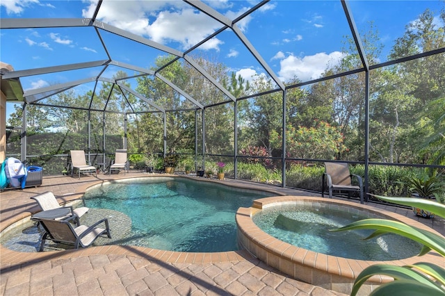 view of pool featuring glass enclosure, an in ground hot tub, and a patio area