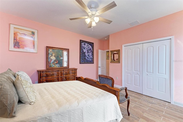 bedroom featuring ceiling fan, light wood-type flooring, and a closet