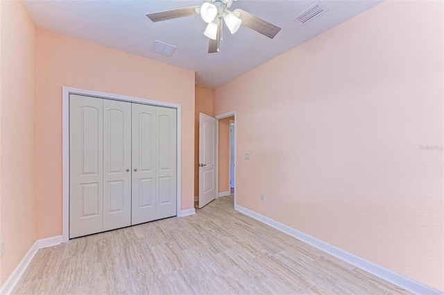 unfurnished bedroom with ceiling fan, a closet, and light hardwood / wood-style flooring