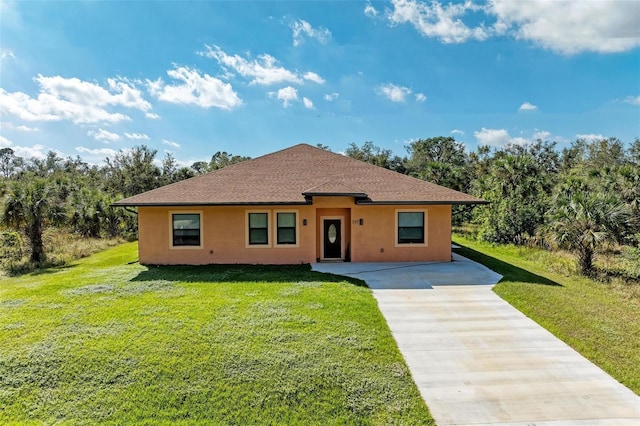 397 Doniphan Dr, Port Charlotte, FL 33954 - view of front of house featuring stucco siding, driveway, a front lawn, and roof with shingles