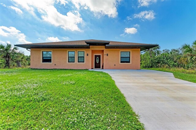 397 Doniphan Dr, Port Charlotte, FL 33954 - view of front of home with stucco siding, driveway, and a front yard