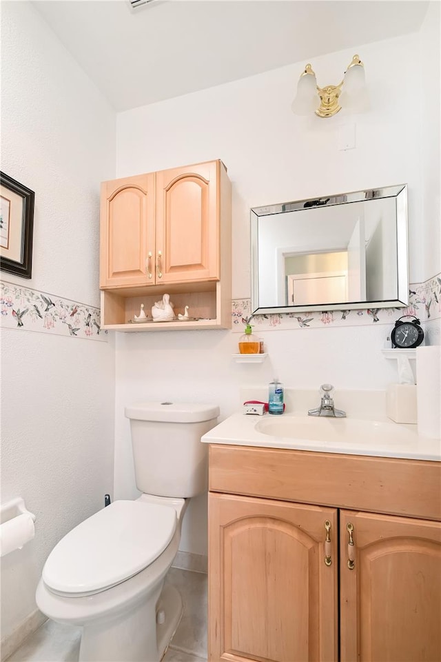 bathroom featuring tile patterned flooring, vanity, and toilet