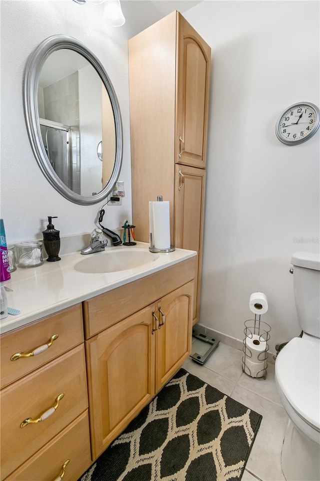 bathroom with tile patterned floors, vanity, toilet, and an enclosed shower