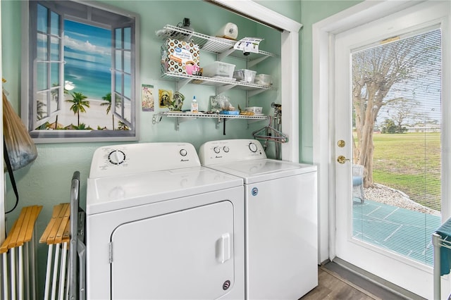 clothes washing area with washer and clothes dryer and dark wood-type flooring