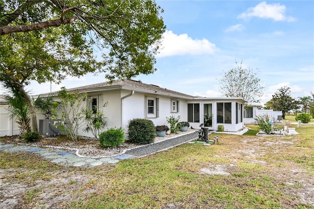 view of front of house with a sunroom and a front lawn