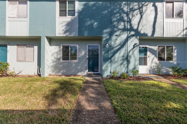 townhome / multi-family property featuring a front lawn