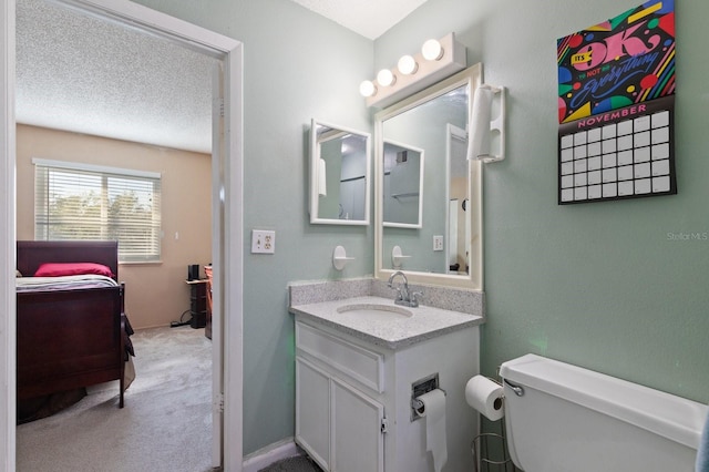 bathroom featuring vanity, toilet, and a textured ceiling