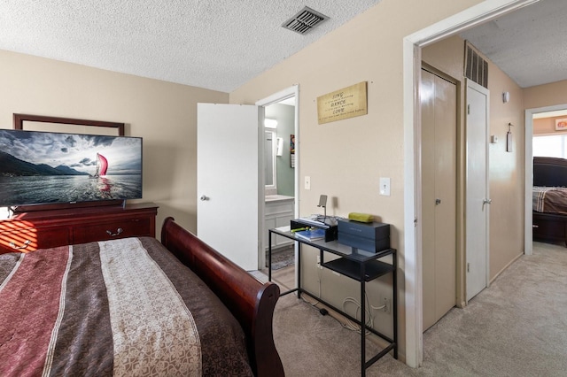 bedroom featuring light carpet and a textured ceiling