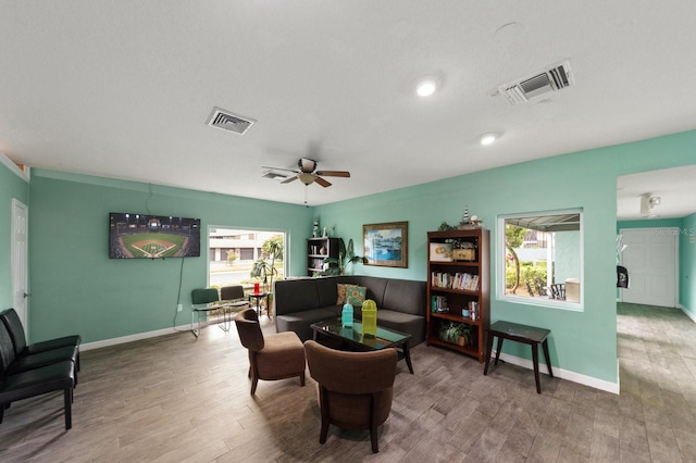 living area with wood-type flooring and ceiling fan