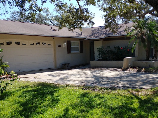 ranch-style house featuring a garage and a front lawn