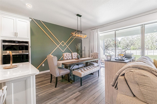 dining space featuring wood-type flooring and a textured ceiling