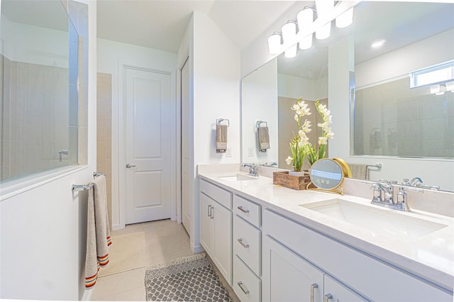 bathroom with tiled shower, vanity, and tile patterned floors