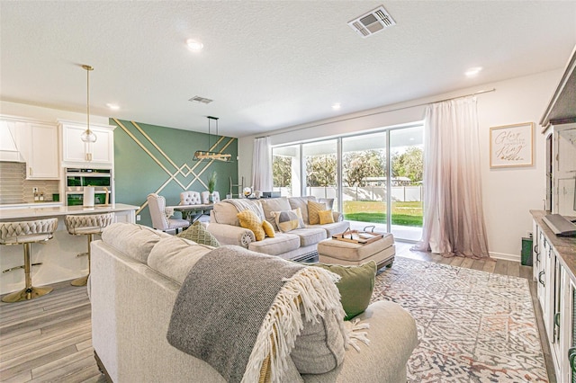 living room featuring light hardwood / wood-style floors and a textured ceiling