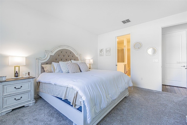 bedroom with hardwood / wood-style floors and connected bathroom