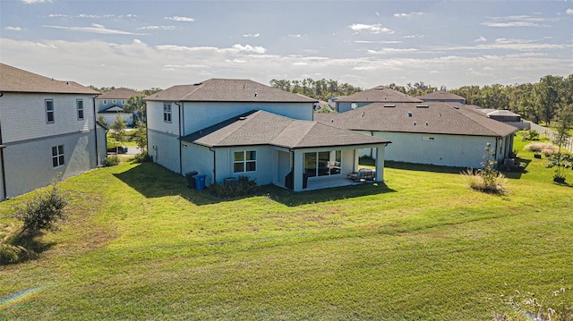 rear view of house featuring a patio and a lawn