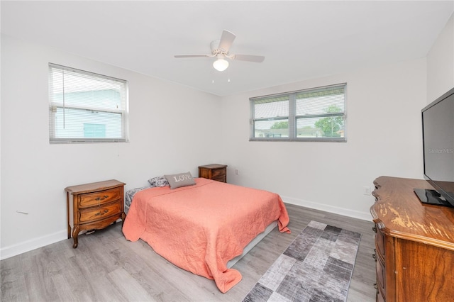 bedroom with multiple windows, ceiling fan, and light wood-type flooring