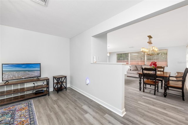 living room featuring light hardwood / wood-style flooring and a notable chandelier