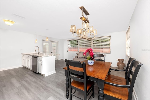 dining area featuring dark hardwood / wood-style floors, an inviting chandelier, sink, and french doors