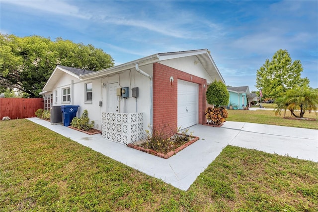 view of side of home with a yard, central AC unit, and a garage