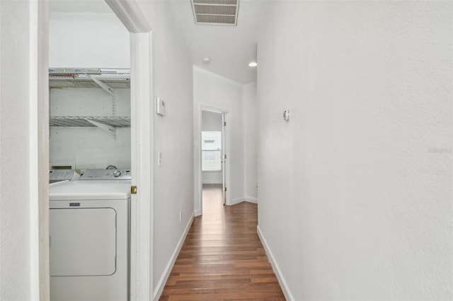 laundry room featuring dark hardwood / wood-style flooring and washing machine and dryer