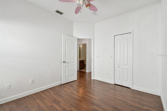 unfurnished bedroom with a closet, dark hardwood / wood-style floors, and ceiling fan