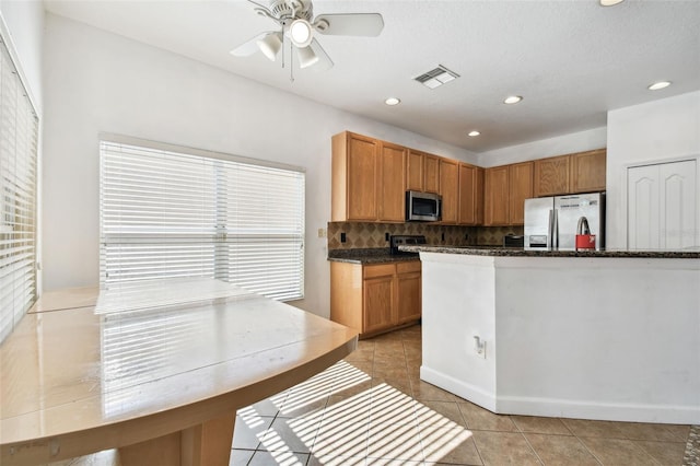 kitchen featuring appliances with stainless steel finishes, tasteful backsplash, light tile patterned floors, and ceiling fan