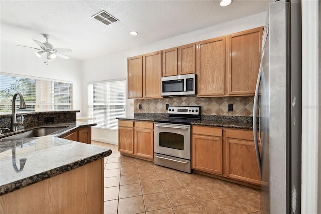 kitchen featuring light tile patterned flooring, backsplash, stainless steel appliances, and sink