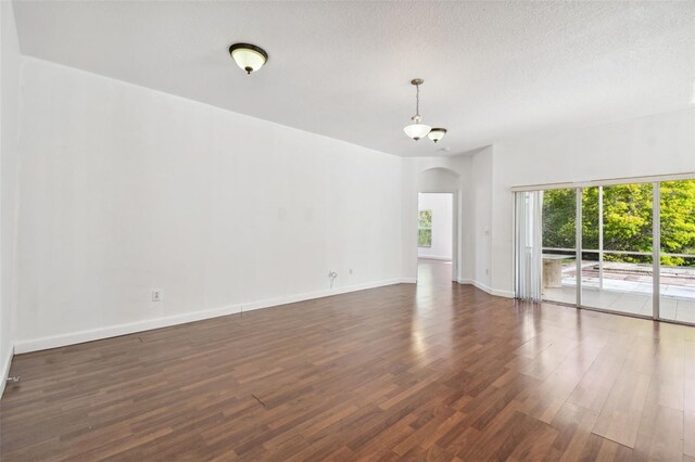 spare room with dark hardwood / wood-style flooring and a textured ceiling