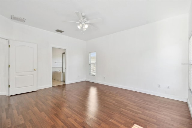 unfurnished bedroom with ceiling fan, ensuite bathroom, and dark wood-type flooring