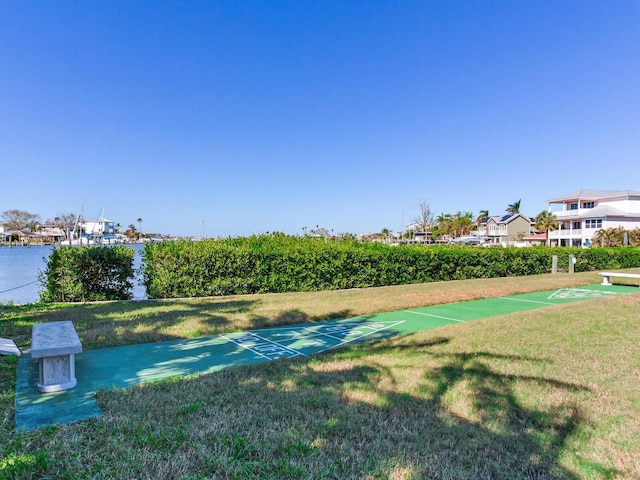 view of property's community featuring a yard and a water view