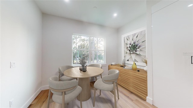 dining area with light wood-type flooring and baseboards