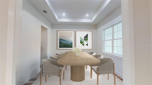 dining space featuring baseboards, visible vents, wood finished floors, a tray ceiling, and recessed lighting