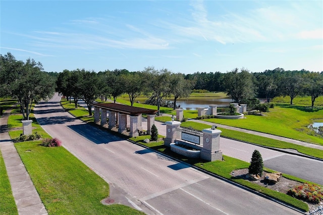 view of road with a water view, sidewalks, and curbs