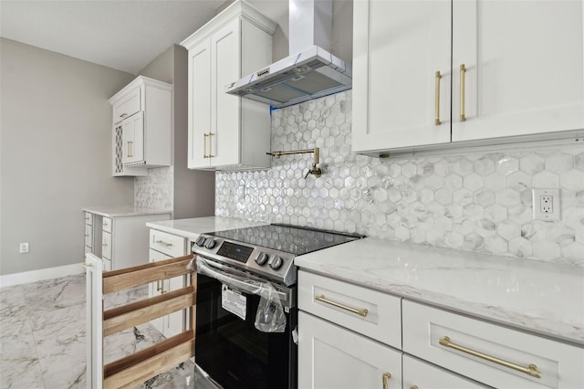 kitchen featuring white cabinets, stainless steel electric range oven, light stone countertops, and wall chimney range hood