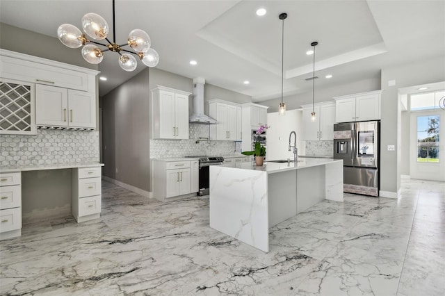 kitchen featuring decorative backsplash, decorative light fixtures, stainless steel appliances, and wall chimney range hood