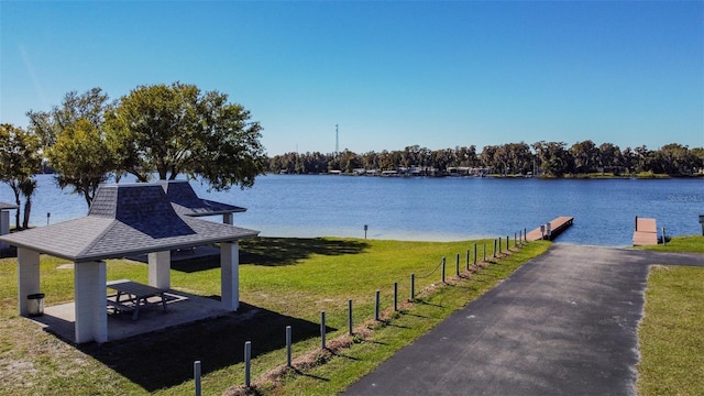 exterior space featuring a gazebo, a water view, and a lawn