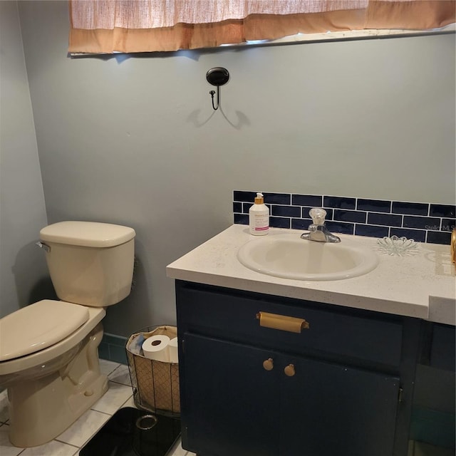 bathroom featuring tile patterned flooring, vanity, toilet, and backsplash