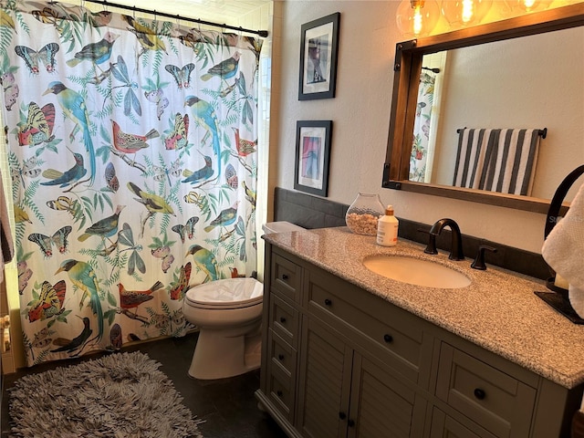 bathroom with tile patterned flooring, vanity, and toilet