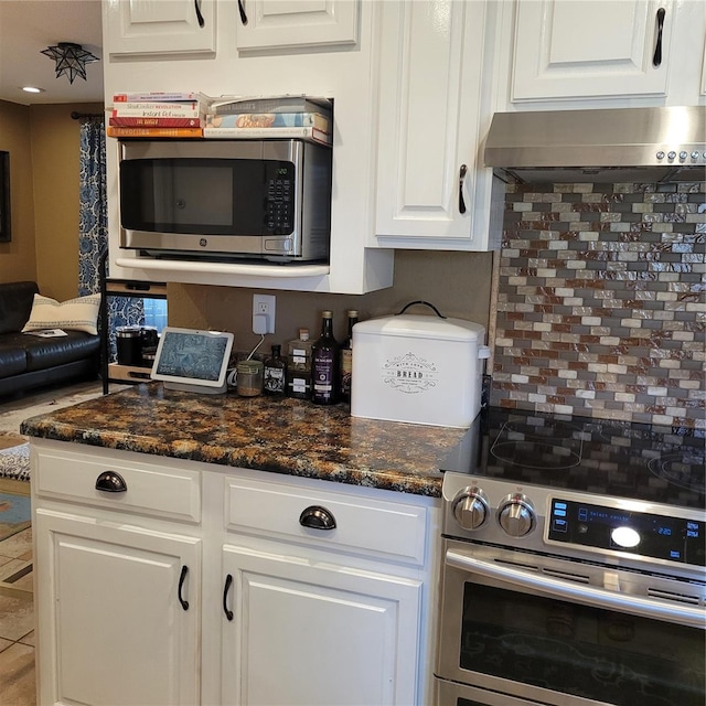 kitchen featuring backsplash, white cabinets, wall chimney exhaust hood, and appliances with stainless steel finishes