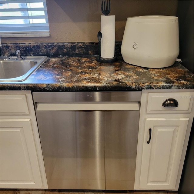 details featuring stainless steel dishwasher, dark stone countertops, white cabinetry, and sink